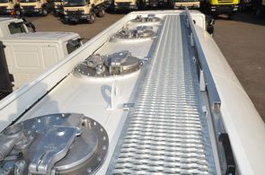 Open mesh walkway with rear mounted access ladder and collapsible handrail on top of the fuel tank